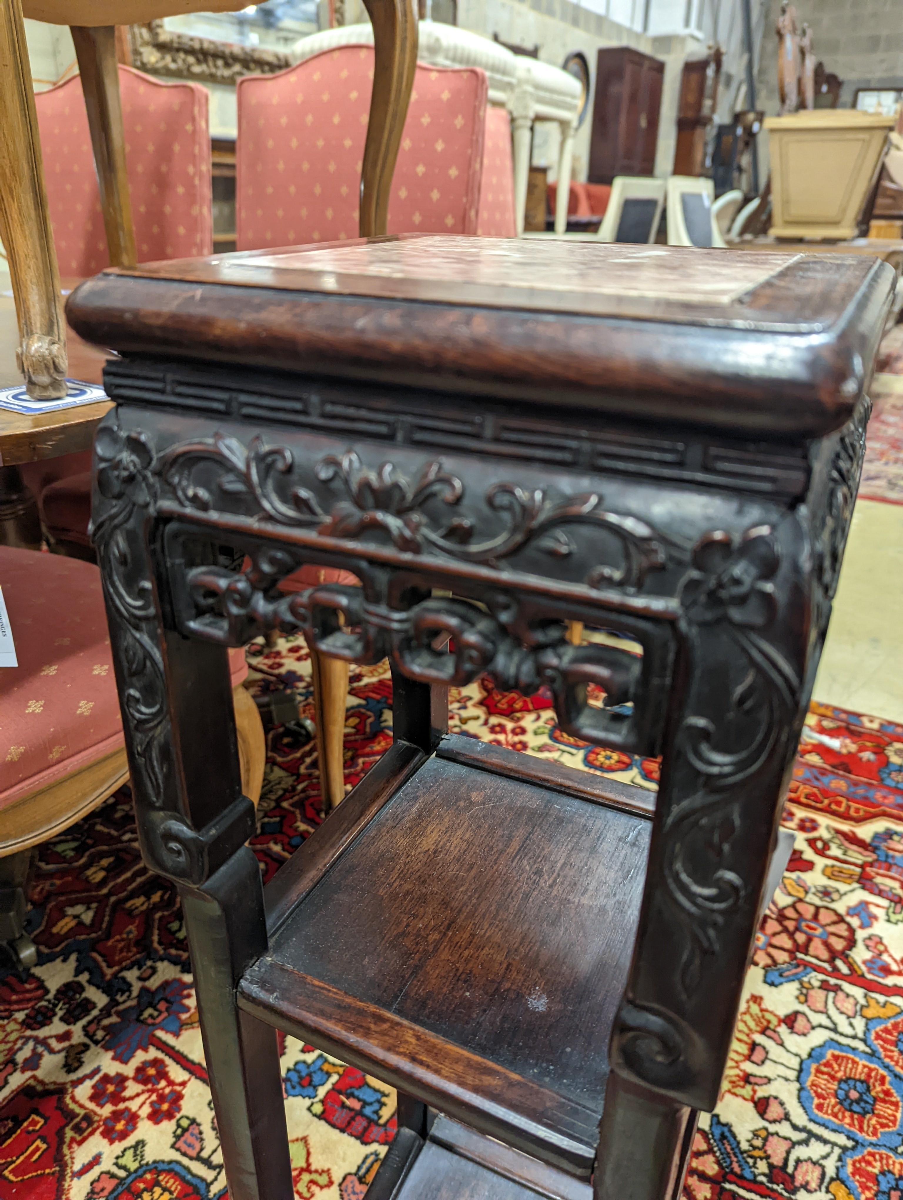 A Chinese carved hardwood three tier jardiniere stand, marble inset, width 22cm, depth 22cm, height 82cm